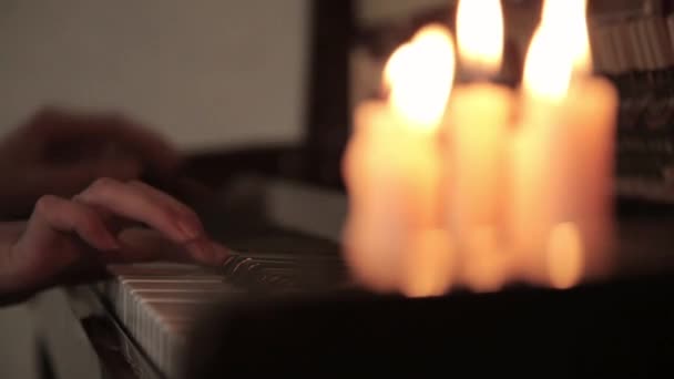 Jouer du piano. mains féminines jouant du piano de lumière de bougie. Les doigts sur le piano . — Video