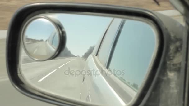 Camino de vuelta reflejado en el espejo del coche, coche conduciendo rápido en una autopista — Vídeo de stock