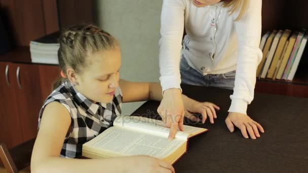 Mamá ayudando a su hija a hacer la tarea. colegiala hace lecciones — Vídeos de Stock