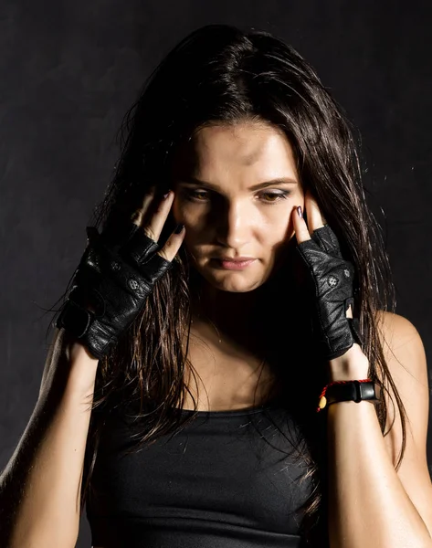 beautiful sexy female boxer or mma fighter wearing black gloves on a dark background