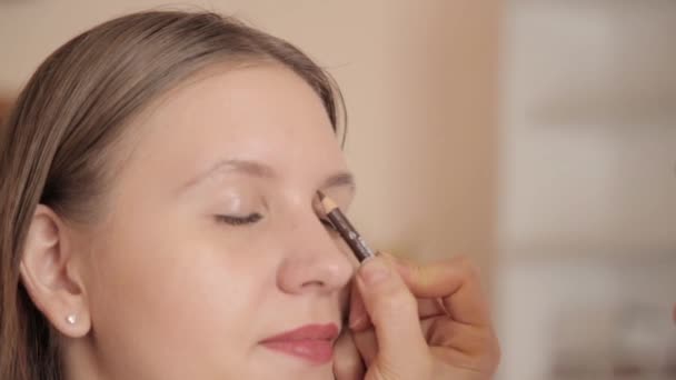 Make-up artist Rita ögonbryn av klienten av penna. Nära upp skott. — Stockvideo