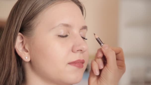 Make-up artist rysunek brwi klienta przez ołówek. Strzał z bliska. — Wideo stockowe