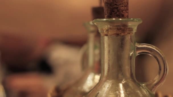 Botellas con condimentos en un café. Tapones de corcho, cuerpo de vidrio. personas comiendo en un fondo borroso — Vídeo de stock