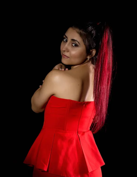 Bella giovane sexy modello asiatico con i capelli rossi in sorprendente vestito rosso su sfondo scuro — Foto Stock