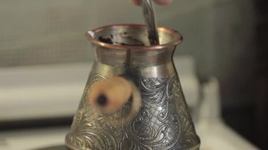 Bir kaşıkla karıştırarak bir elektrikli ocakta kahve demlemek