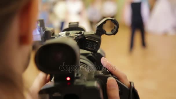 Operador dispara una película y mirando en la pantalla de la videocámara durante el rodaje — Vídeos de Stock