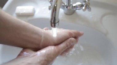 Adam lathers ve ellerini yıkar. Spreyler su ile temizlik el. Hijyen