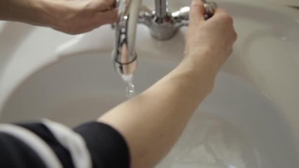Девушка стирает и вытирает руки полотенцем. крупным планом только руки и брызги воды — стоковое видео