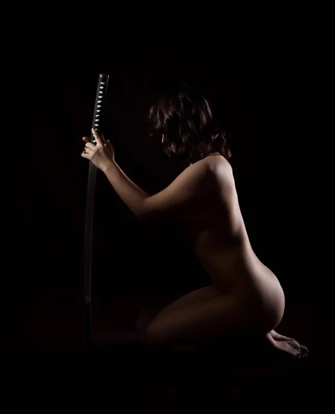 Belle femme sexy avec épée samouraï sur fond noir — Photo