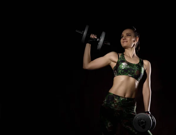 Seksi Kız Fitness karanlık bir arka plan üzerinde dumbbells ile. Atlet spor yapıyor. Metniniz için boş alan — Stok fotoğraf