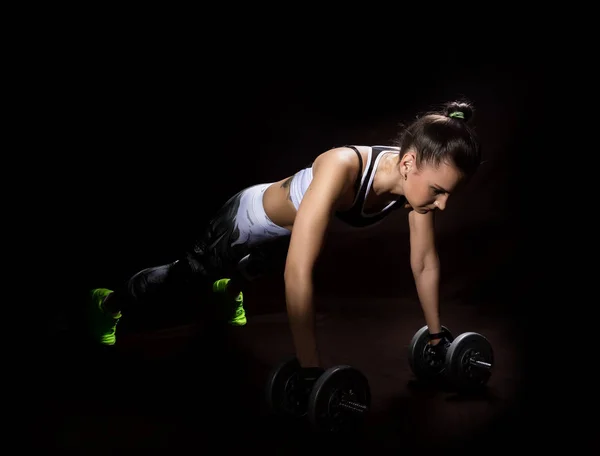Seksi Kız Fitness karanlık bir arka plan üzerinde. Atlet spor yapıyor — Stok fotoğraf