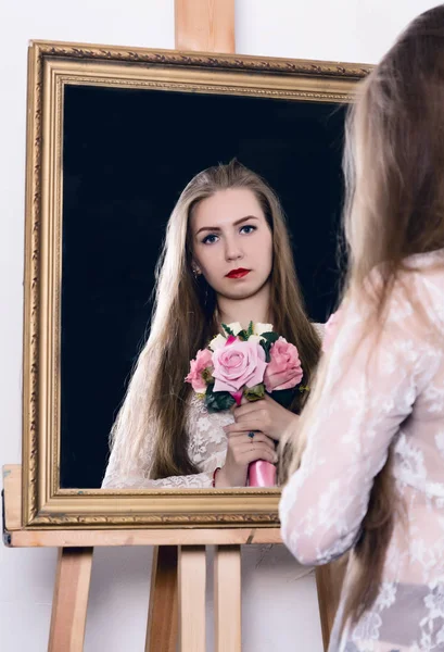 Belleza mujer joven sosteniendo un ramo de primavera y se mira en el espejo como su retrato —  Fotos de Stock