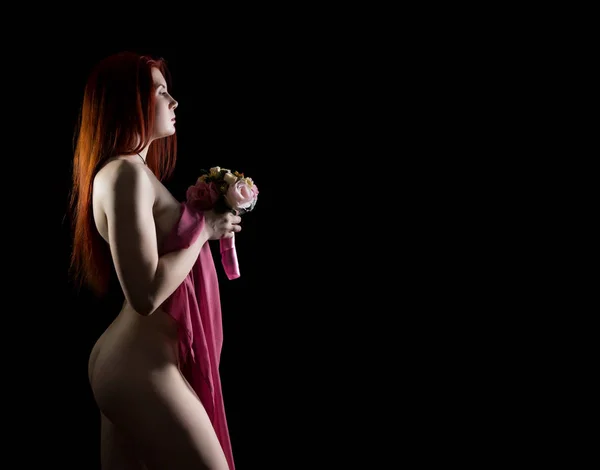 Belle rousse fille nue tenant des fleurs sur un fond sombre. Espace libre pour le texte — Photo