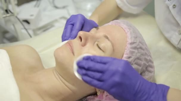 Una donna in cura alla spa. Massaggiatrice pulizia viso donna con tamponi di cotone a spa — Video Stock