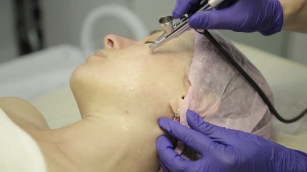 Beautician hands at work, doing face cleaning on a beautiful girl face, cleaning skin with water jet. — Stock Video