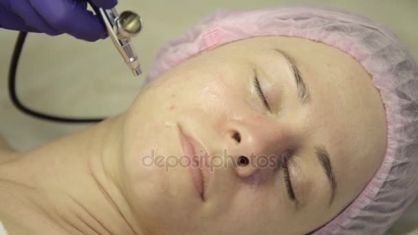 Hermosa mujer recibiendo un tratamiento de medicina cosmética. esteticista haciendo limpieza facial en una hermosa cara de niña, limpieza de la piel con chorro de agua — Vídeos de Stock