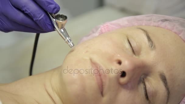 Mulher bonita recebendo um tratamento de medicina cosmética. Esteticista fazendo limpeza facial em um belo rosto de menina, limpeza da pele com jato de água — Vídeo de Stock