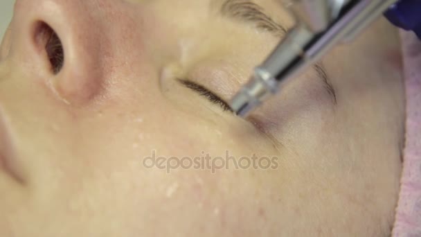 Hermosa mujer recibiendo un tratamiento de la piel facial. esteticista haciendo limpieza facial en una hermosa cara de niña, limpieza de la piel con chorro de agua — Vídeo de stock