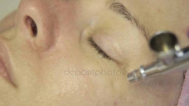 Hermosa mujer recibiendo un tratamiento de la piel facial. esteticista haciendo limpieza facial en una hermosa cara de niña, limpieza de la piel con chorro de agua — Vídeos de Stock