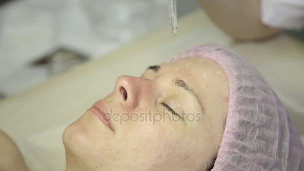 Bela mulher recebendo um tratamento da pele facial. Esteticista fazendo limpeza facial em um belo rosto de menina, limpeza da pele com jato de água — Vídeo de Stock