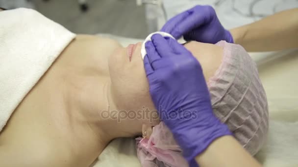 Woman receiving spa treatment. Masseuse cleaning woman face with cotton swabs at spa — Stock Video