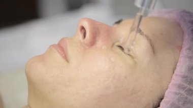 Güzellik Cilt Bakımı close-up. Güzellik uzmanı kadın yüzünde bir yağı maskesi uygular