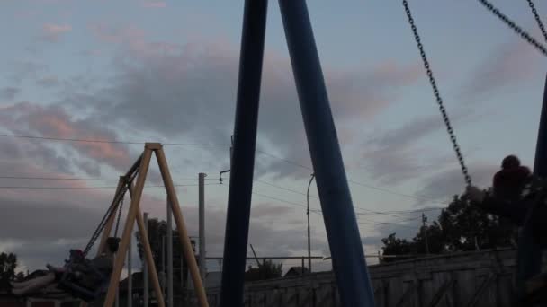 Sad child swinging on a swing on a dark sky background. child abuse, painful childhood — Stock Video