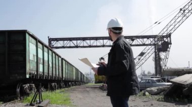 Tren trafik eleştirileri telsiz üzerinde konuşurken Müfettiş. Beyaz kask planları planı tutan demiryolu işçisi