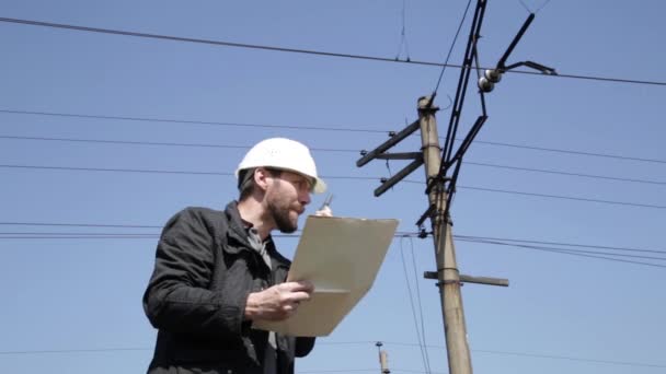 Ingenieur-Check elektrische Systeme reden Walkie-Talkie, Inspektor hält Baupläne — Stockvideo