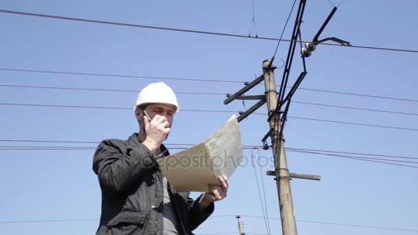 Ingenjören kontrollera elektriska system prata walkie-talkie, inspektör holding ritningar plan — Stockvideo