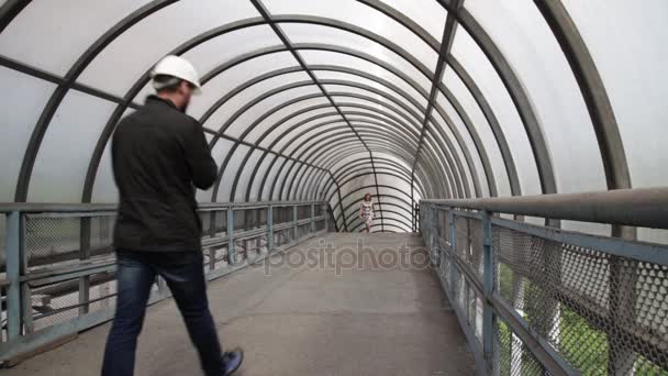 Ingénieur dans un casque blanc et belle femme élégante marchant dans les escaliers — Video