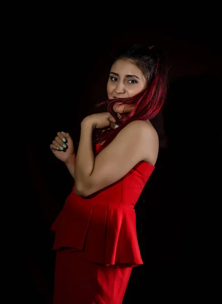 Όμορφη νεαρή σέξι ασιατικό μοντέλο με τα κόκκινα μαλλιά στο εκπληκτικό κόκκινο φόρεμα σε σκούρο φόντο — Φωτογραφία Αρχείου