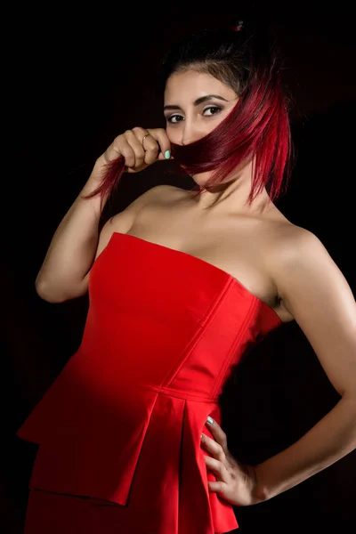 Dość młoda seksowna Azjatka model z rude włosy w niesamowite czerwona sukienka na ciemnym tle — Zdjęcie stockowe