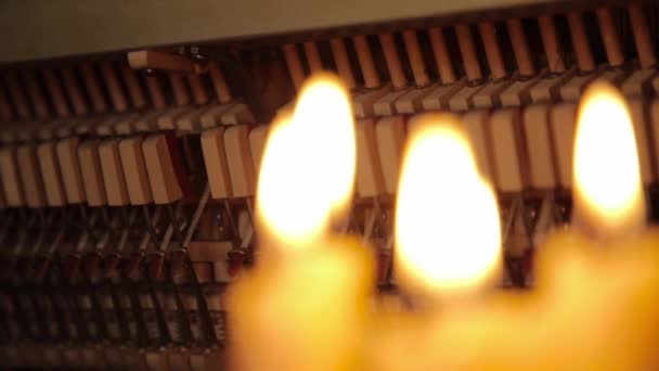 Piano dovnitř, vnitřní struktura klavír, kladiva a klíče ve světle svíček. — Stock video