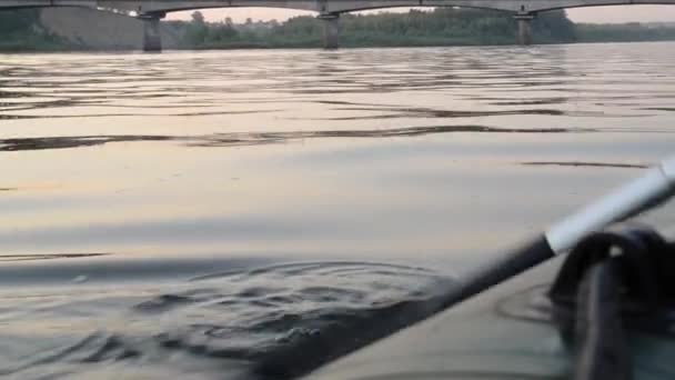 Boot vaart langs de rivier, riem van boot water raken en het veroorzaken van splash en rimpelingen in het water. — Stockvideo