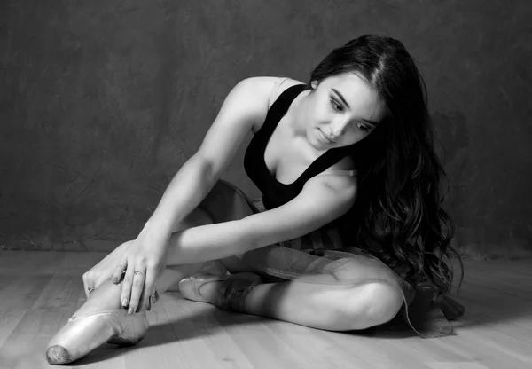 Młoda piękna kobieta w pointe buty siedzi na podłodze. czarno-białe — Zdjęcie stockowe