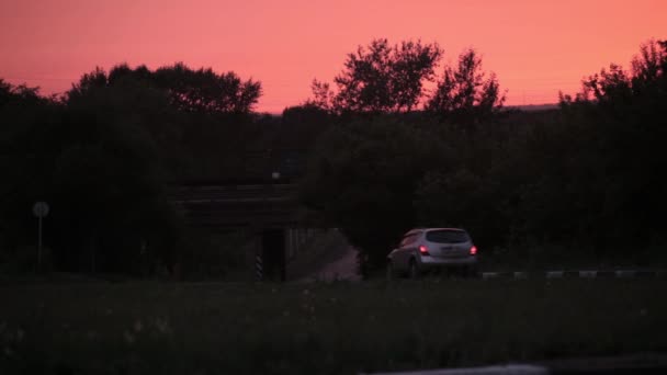 Heldere oranjerode zon opkomt over weg, electro transmissielijnen, gebouwen en bomen. — Stockvideo