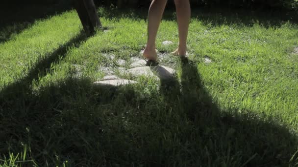 Chica en un columpio, solo piernas y sombra — Vídeos de Stock