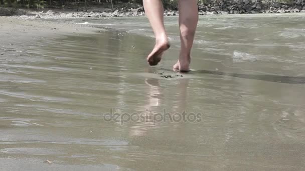 Gars marchant sur le sable le long de la rive des eaux — Video