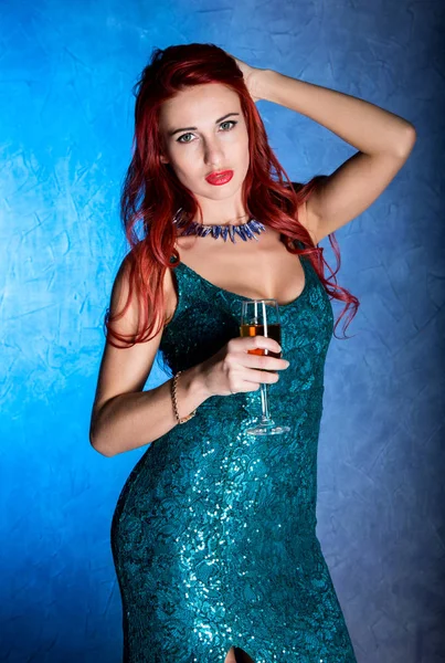 Elegante donna rossa con grandi tette in abito blu stretto con bicchiere da vino con champagne — Foto Stock