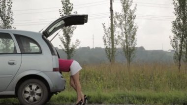 Şaşkın kadın bagajı açar ve bir araçlar alır. Kadın sürücü, acil durum ve sürüş sorunları, düz araba lastik ile sinirli kız