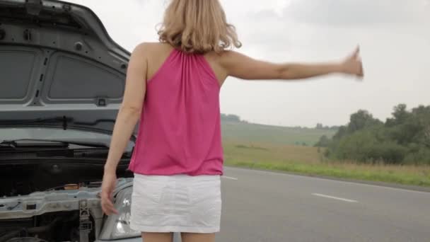 Beautiful woman catching a car near a broken car. female driver problems with a car, emergency situation — Stock Video