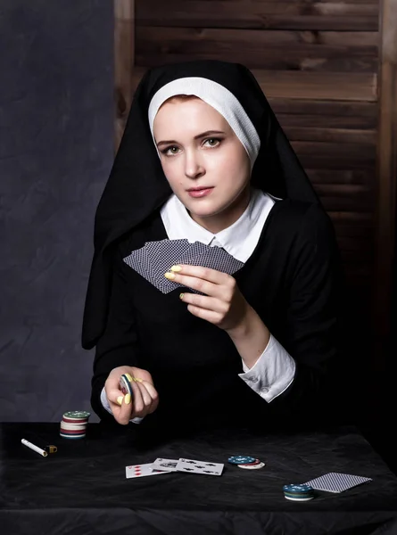 Hermosa monja católica jugando a las cartas. Religión podrida — Foto de Stock