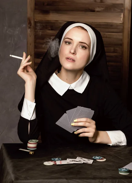 Красива католицька черниця курить і грає в карти. Релігія Гроттен — стокове фото