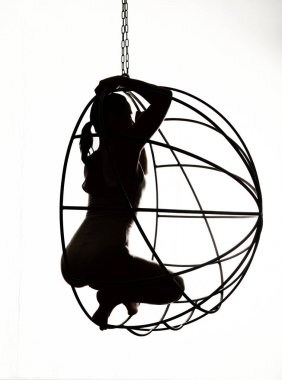 Siyah ve beyaz metal bir salıncak üzerinde seksi bir kadın silüeti