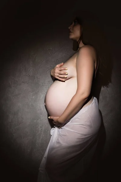 Красивая рыжая беременная женщина на сером фоне — стоковое фото