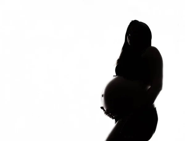 Silhouette of a beautiful pregnant woman on awhite background — Stock Photo, Image