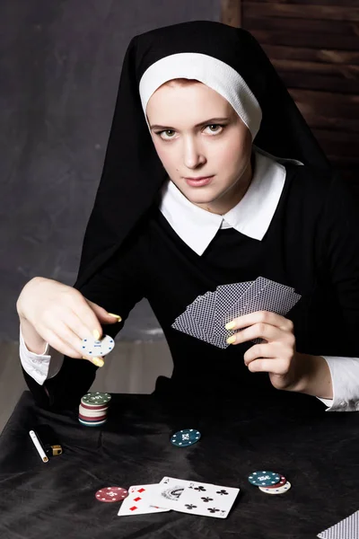 Hermosa monja católica jugando a las cartas. Religión podrida — Foto de Stock