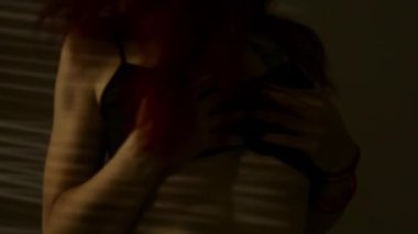 dans ve çizgili bir gölge göğüslerini okşayarak Kızıl saçlı kadın. tutku ve seks oyunları kavramı