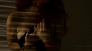 dans ve çizgili bir gölge göğüslerini okşayarak Kızıl saçlı kadın. tutku ve seks oyunları kavramı